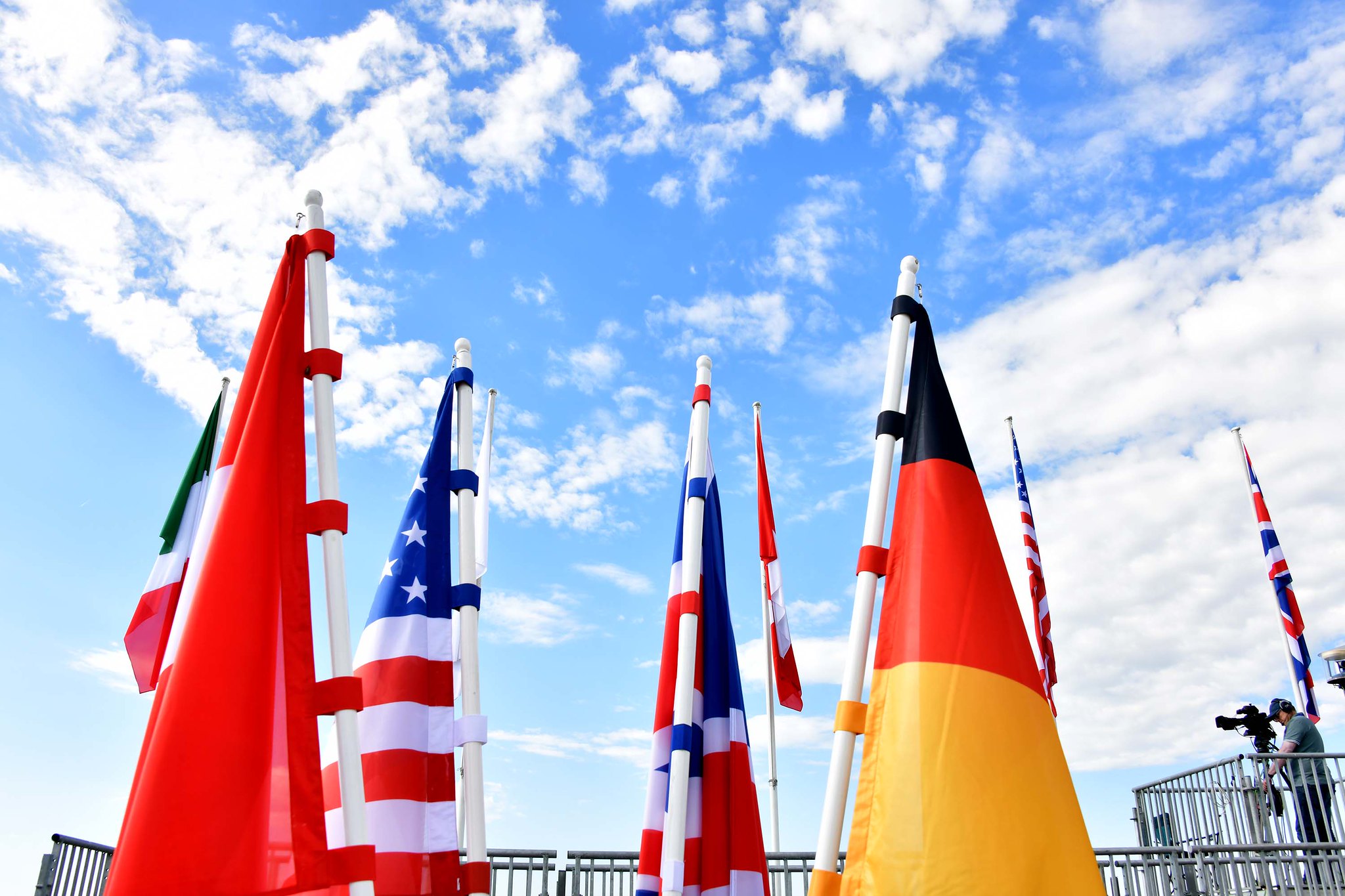 G7 flags visible in front of blue sky