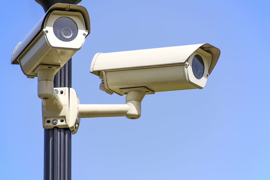 Two surveillance cameras. (Source: https://www.wallpaperflare.com/two-white-surveillance-cameras-monitoring-safety-the-police-wallpaper-zynat)
