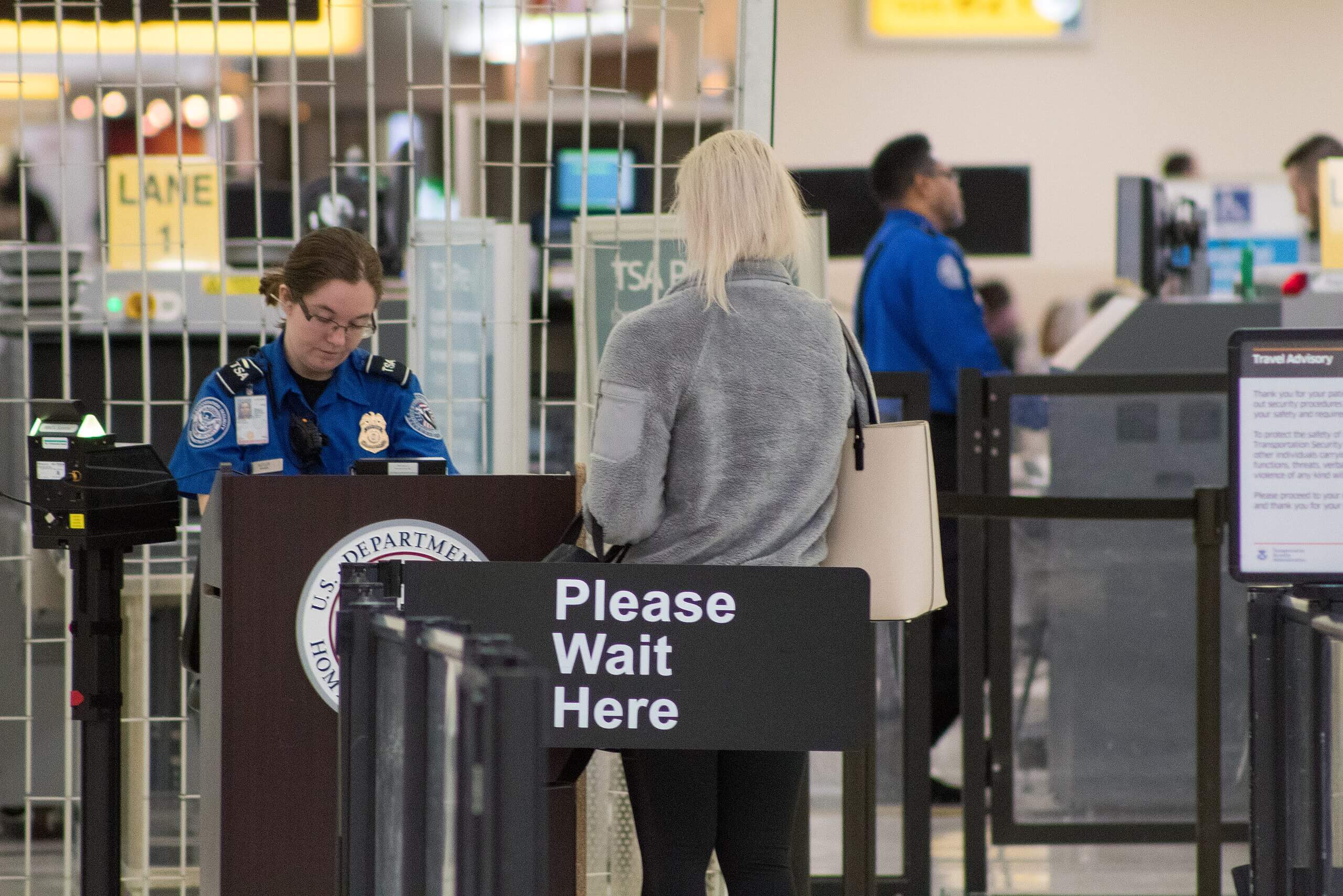 Woman with white hair standing in TSA line at airport