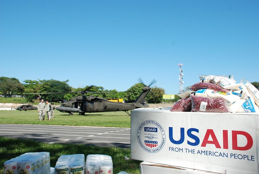 Images of USAID supplies in front of a helicopter